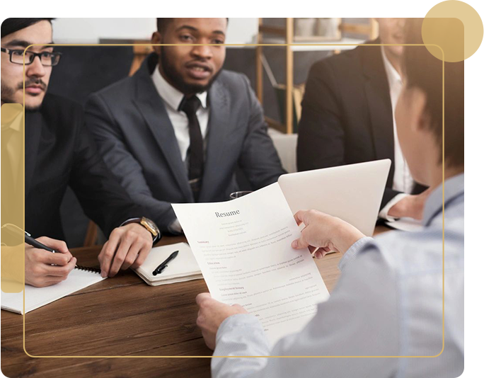 A group of people sitting at a table with papers.